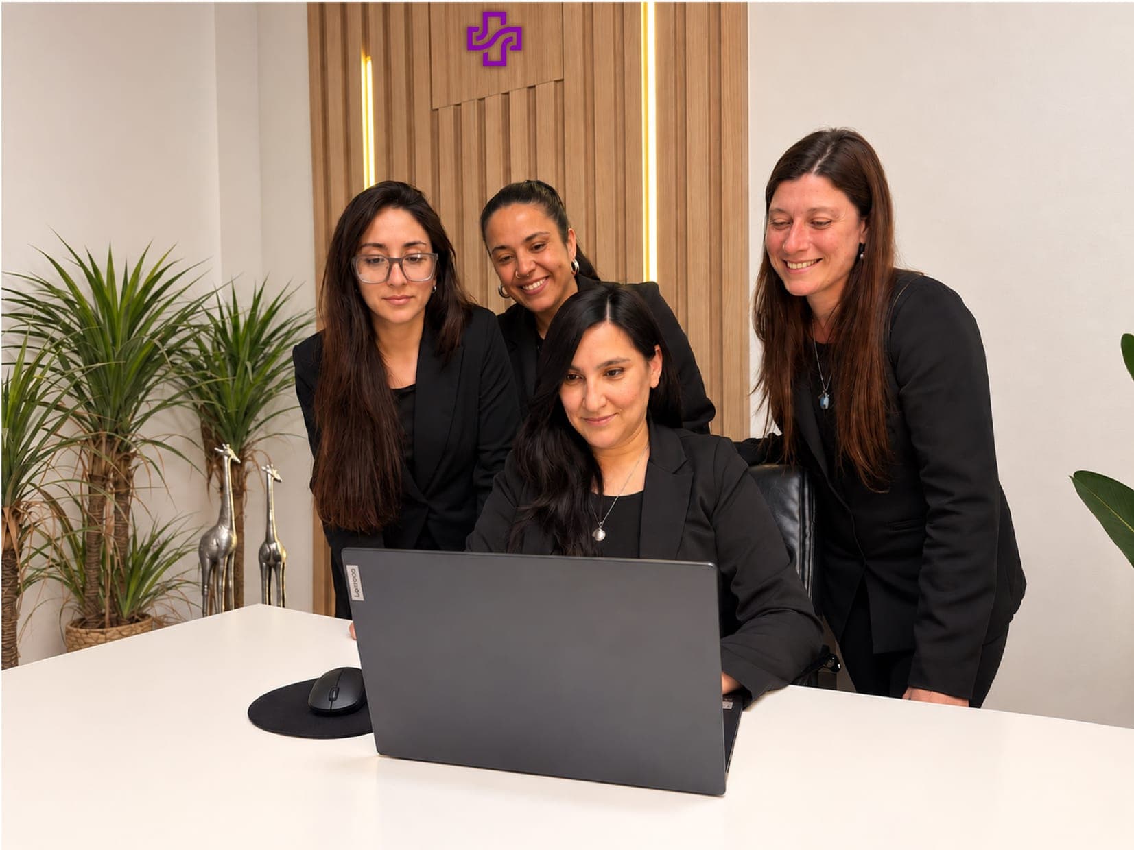 Equipo de coordinación de Más Cuidados revisando una computadora